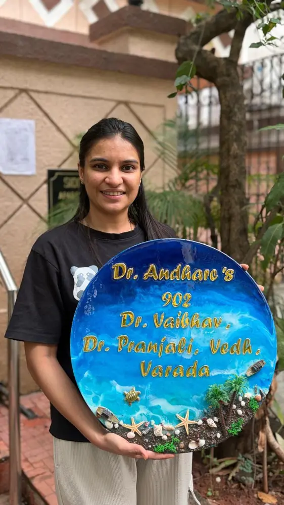 Divya Jain, founder of Divya Creation, holding a blue ocean resin name plate
