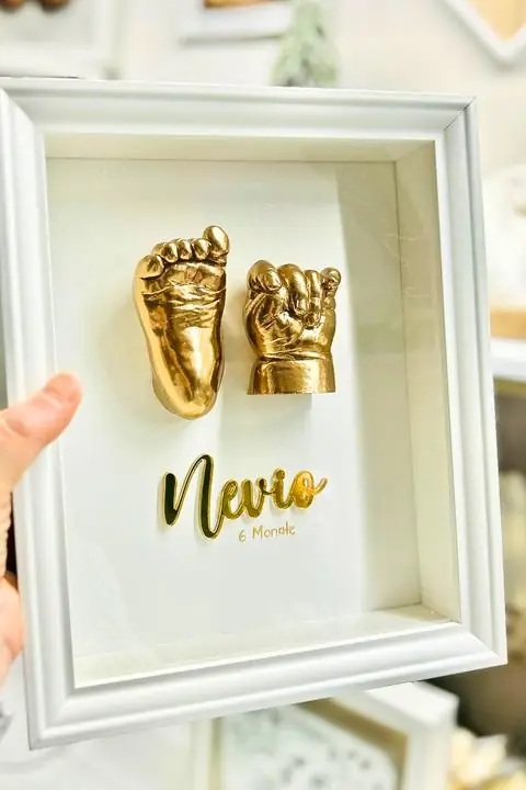 Gold-cast baby hand and foot framed with a name