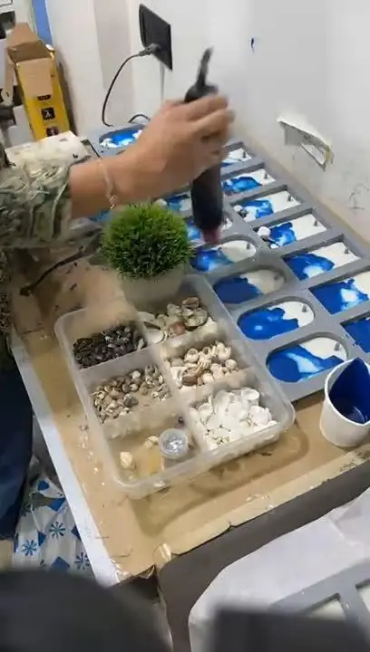 Pouring blue resin into moulds at a workshop
